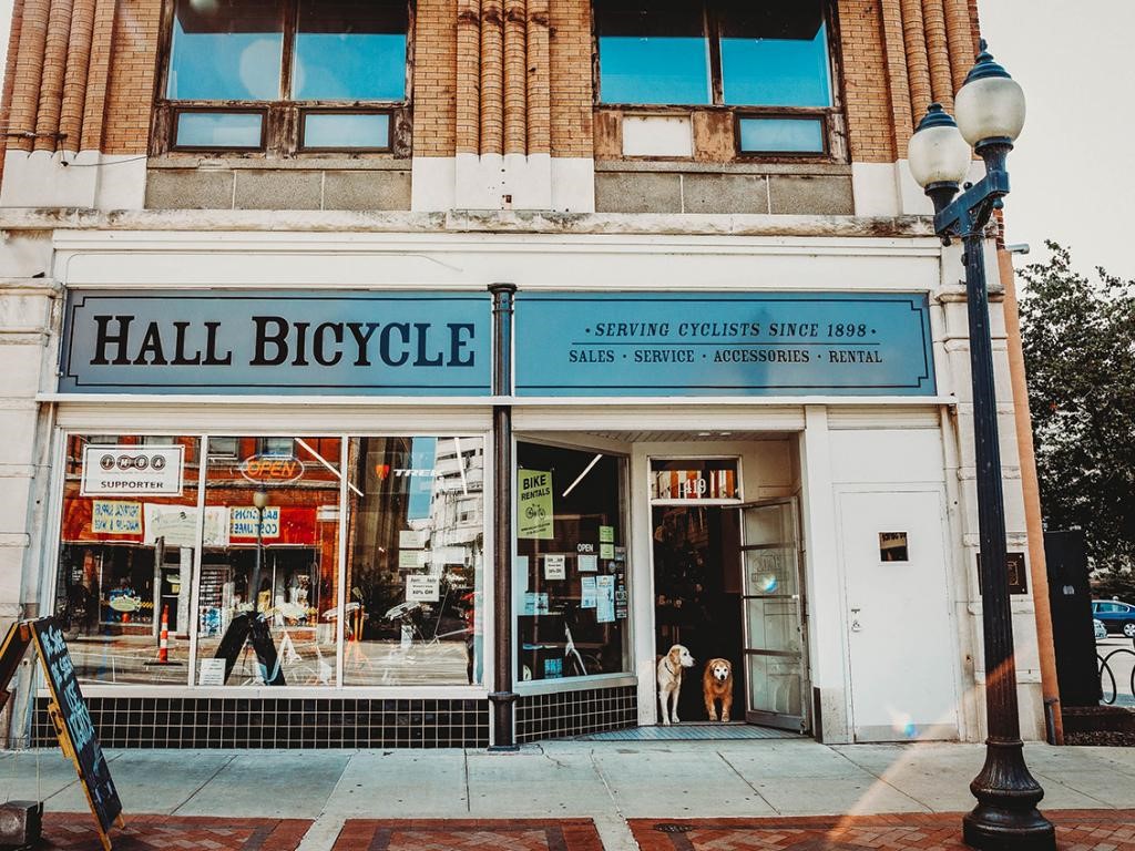 Exterior of Hall Bicycle storefront along a street with a lamppost in front in Cedar Rapids, IA