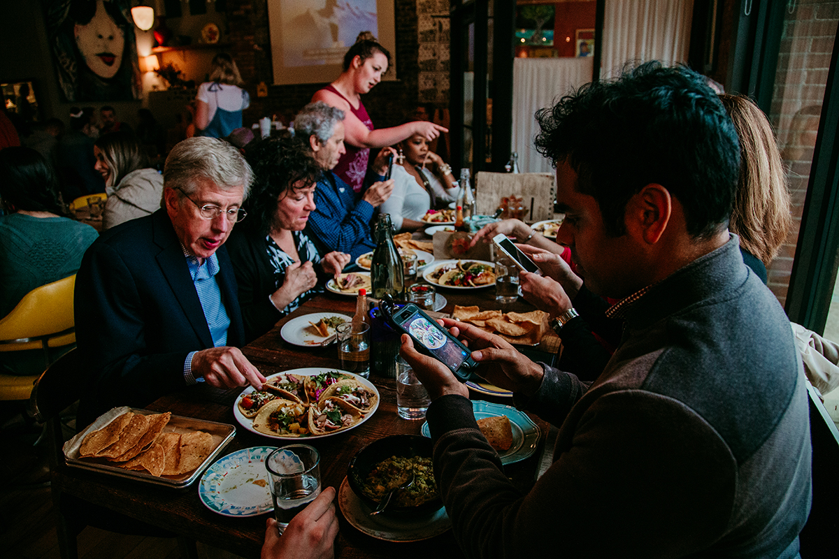 a group of people dining on tacos and other fare at Caucho