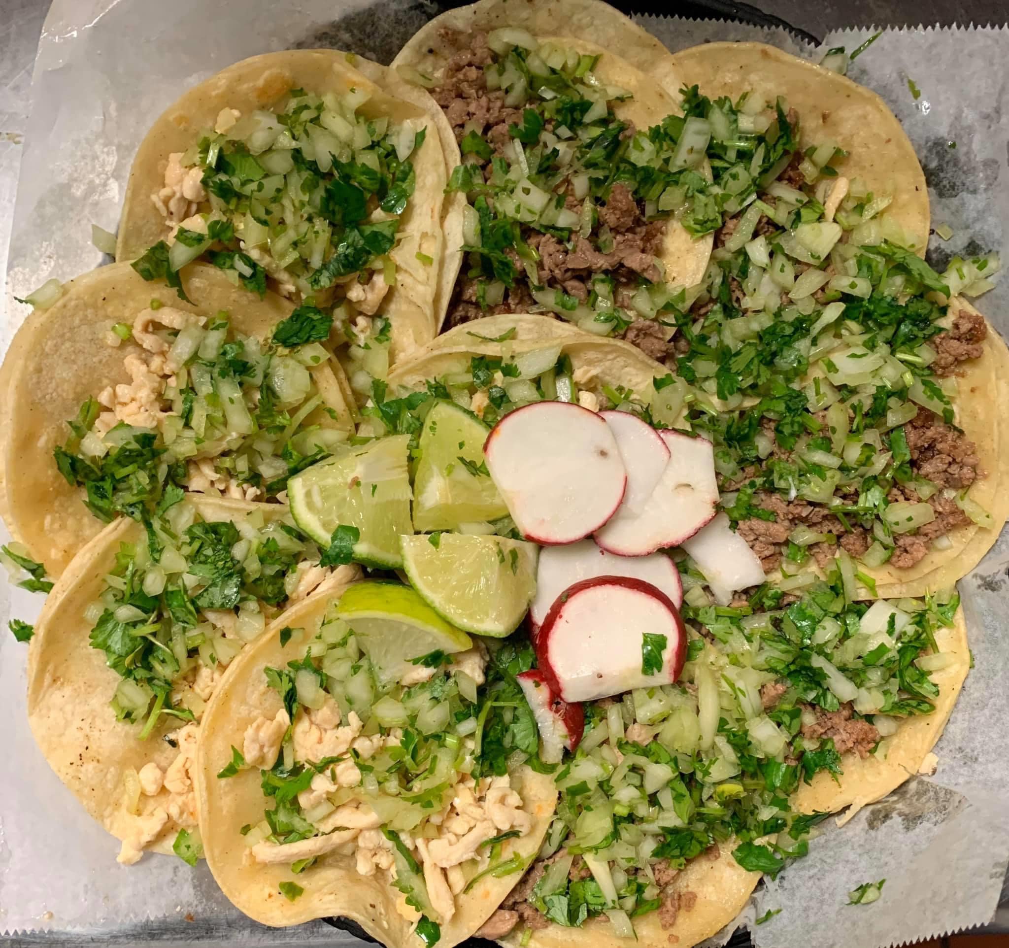 top down view of a platter of ten tacos topped with lime and radish at a mexican restaurant in Cedar Rapids